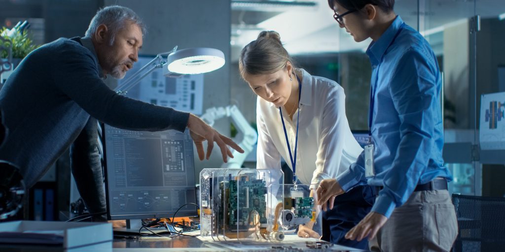 Team,Of,Computer,Engineers,Lean,On,The,Desk,And,Choose Shutterstock
